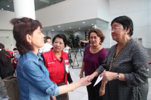 DSWD Secretary Judy M. Taguiwalo ( foreground, right) interacts with one of the repatriates from Riyadh, Saudi Arabia as OIC-Undersecretary Hope Hervilla (in purple blouse) and Social Welfare Attache Office Head Pearl Panganiban (in red vest) look on.