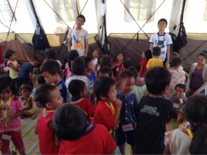 Student volunteers join the children in a sing and dance activity at the Special Day Care Tent at the Grandstand.