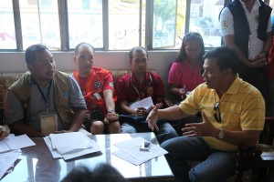 DSWD Assistant Secretary Milo Gudmalin (right) discusses plans and the necessary sanitation and hygiene requirements for affected families staying at the evacuation centers. The meeting was attended by city health officials and DOH  representatives.